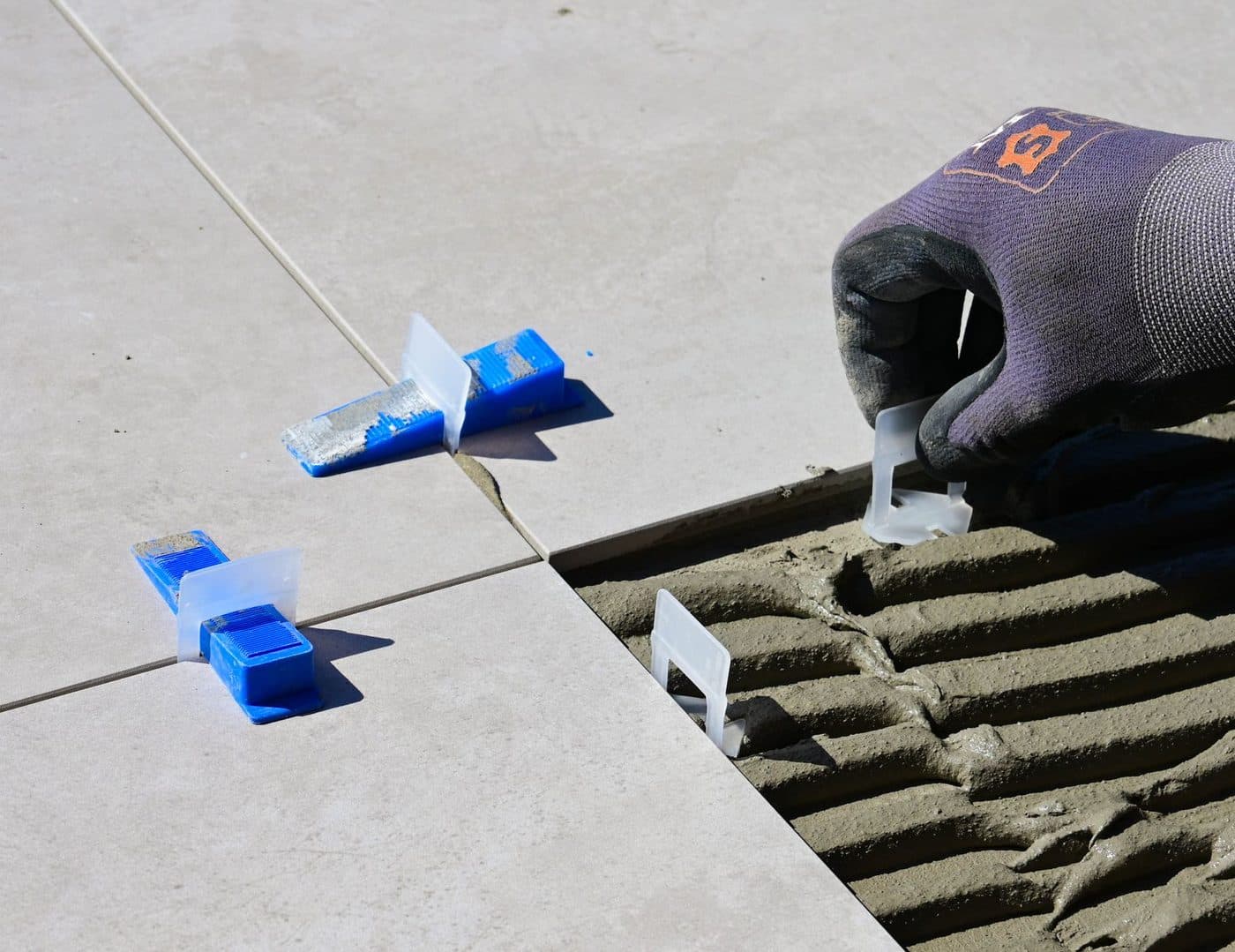 Pose de carreaux de crédence de cuisine derrière un plan de travail
