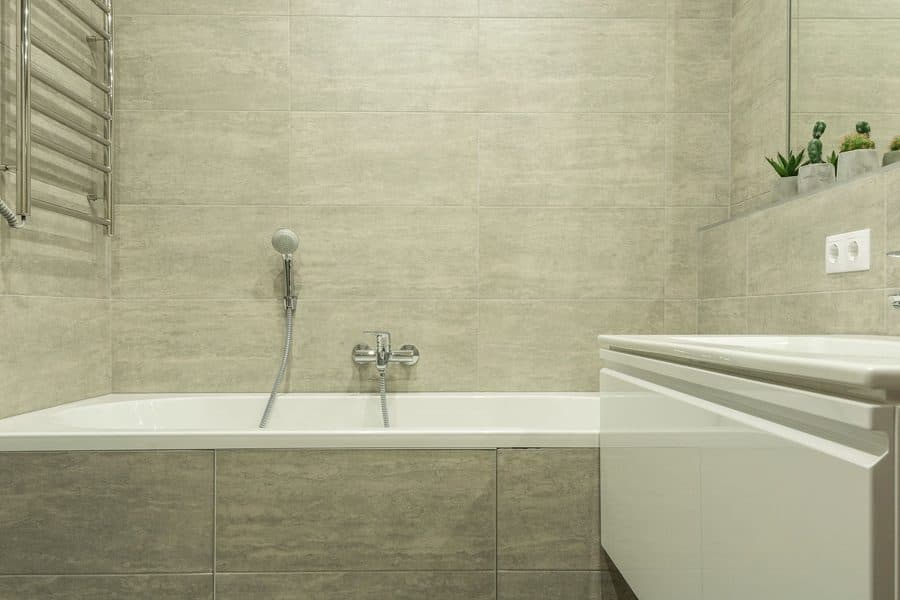 Salle de bain rénovée avec baignoire carrelée